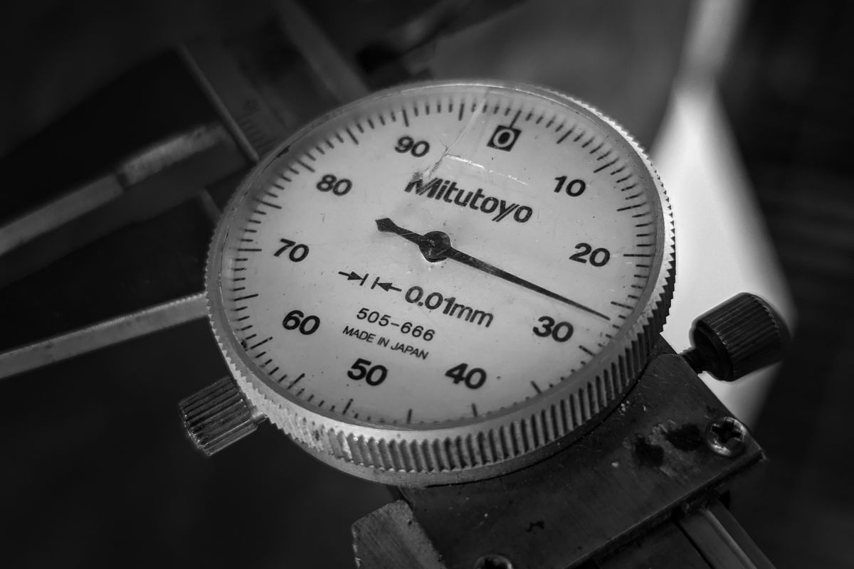Dial indicator set up to check a machined component in a workshop